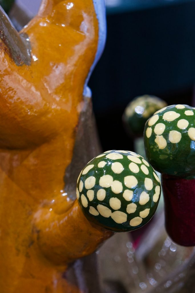 Colorful hand-painted ceramic mushrooms in a vibrant art studio setting - A close-up view of decorative ceramic mushrooms showcasing bright colors and intricate patterns in an artistic space.
